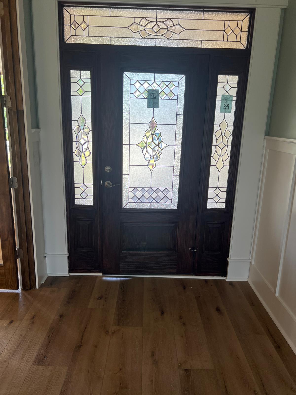Stained wood entry door with leaded glass sidelights and transom, newly installed